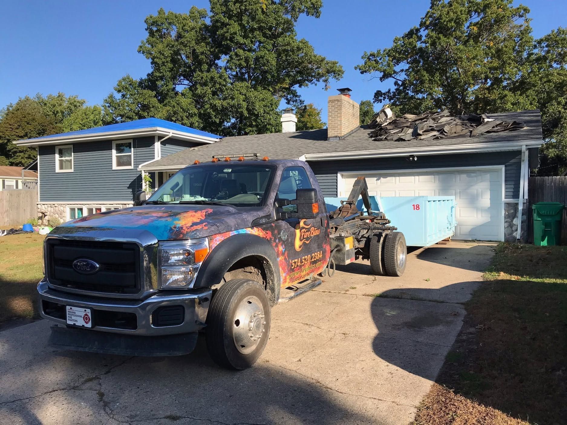 Custom-painted pickup truck parked in a driveway in front of a house and garage.
