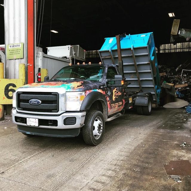 Ford dump truck with raised blue bed inside an industrial garage
