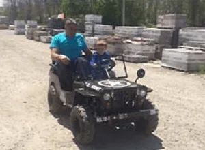 A man and a child are riding a small vehicle