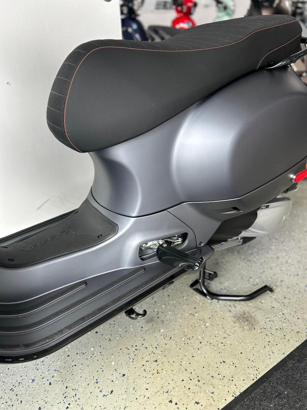A scooter is parked on the floor in a garage.