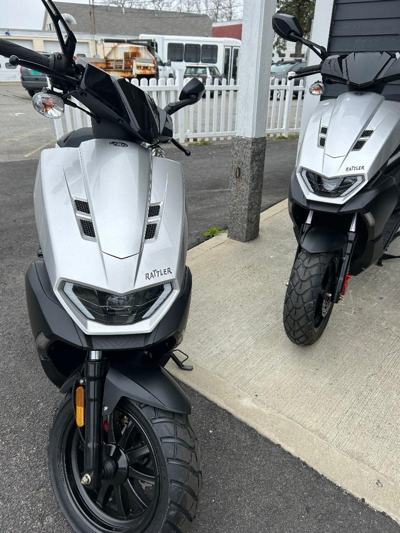 Two scooters are parked next to each other in a parking lot.