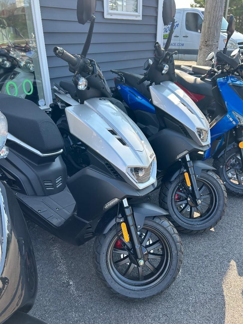 A row of scooters are parked in front of a building.