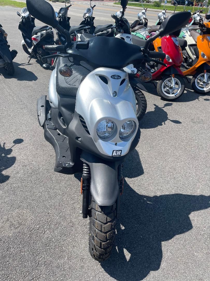 A scooter is parked in a parking lot next to other scooters.