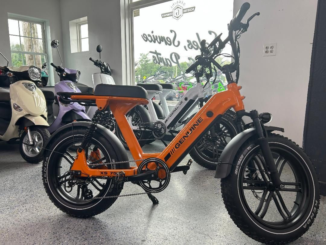 An orange electric bike is parked in a showroom