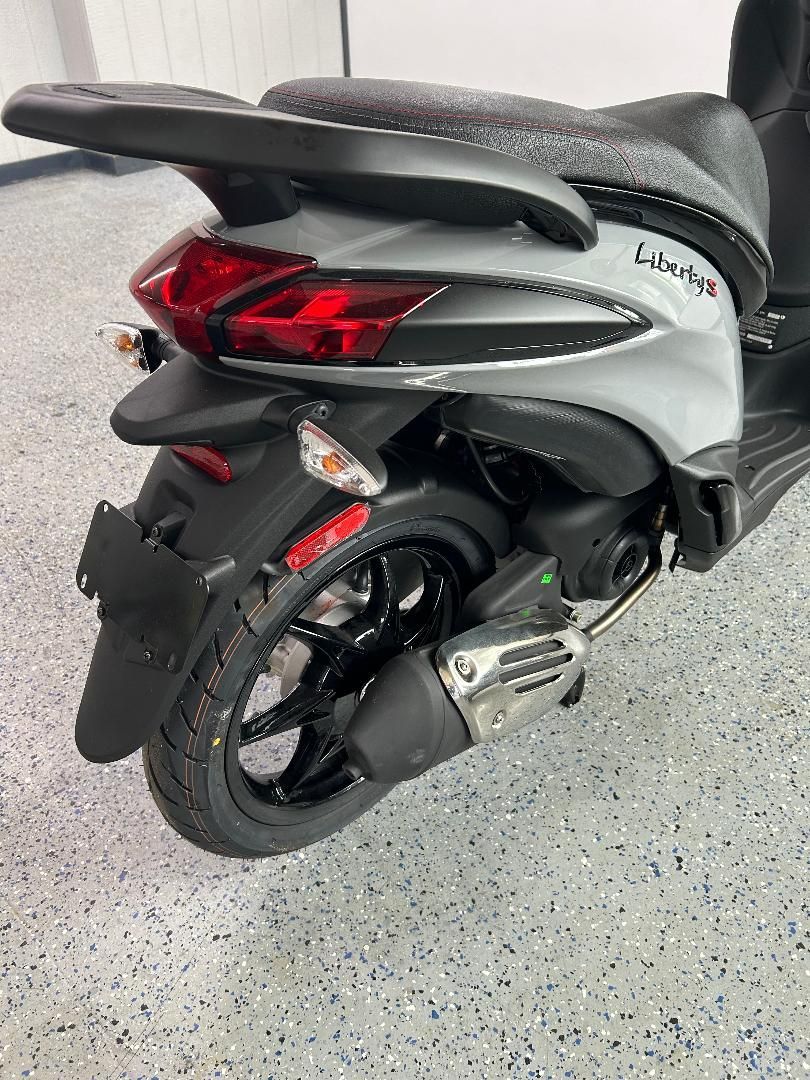 A scooter is parked on a concrete floor in a garage.