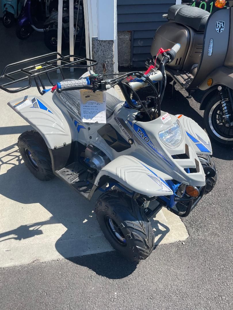 A four wheeler is parked on the side of the road next to a scooter.