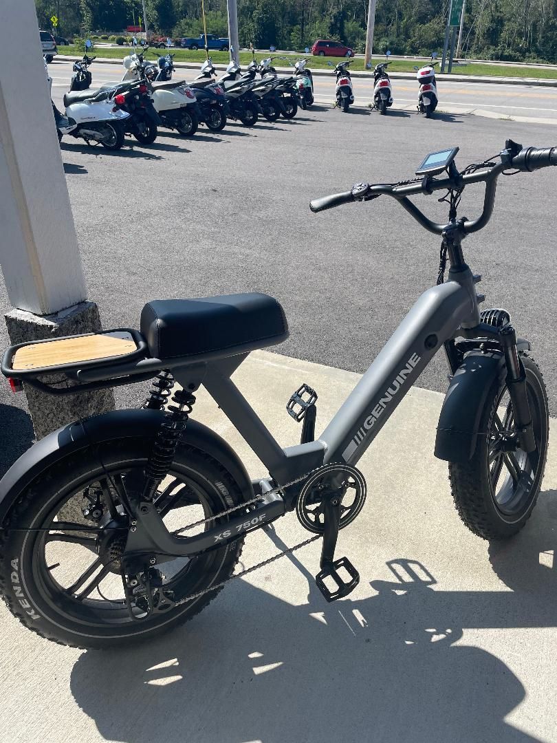 A bicycle is parked on the side of the road in a parking lot.