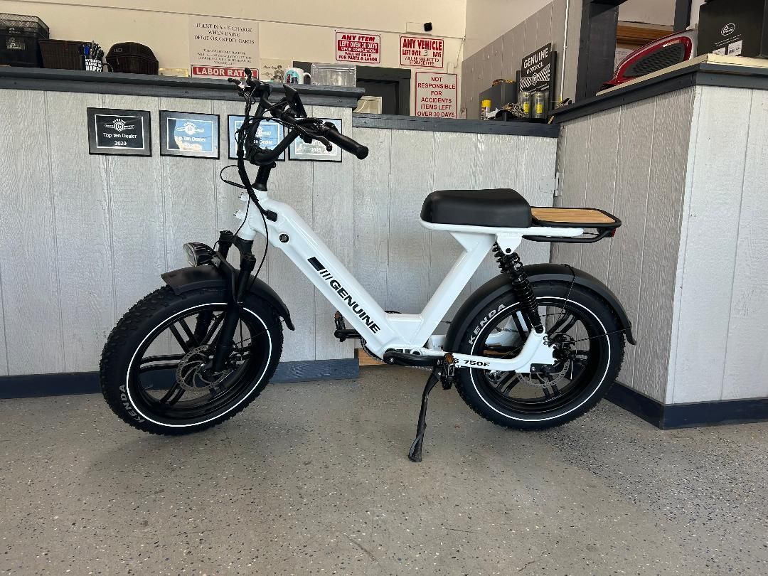 A white scooter is parked in a garage next to a counter.