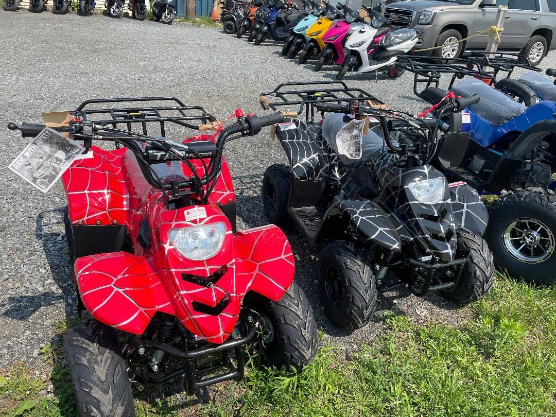 A row of atvs are parked in a grassy field.