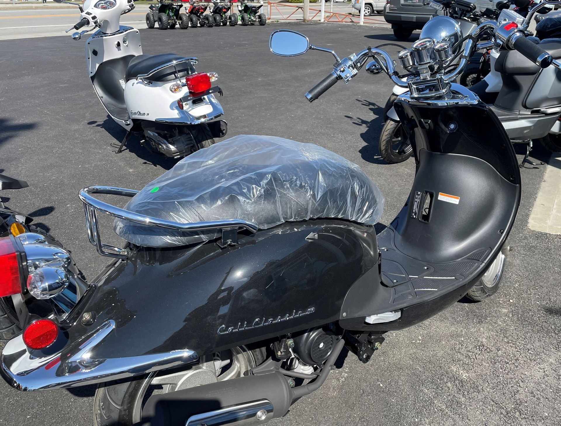A row of scooters are parked in a parking lot
