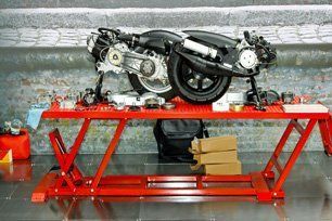 A motorcycle is sitting on top of a red lift table.