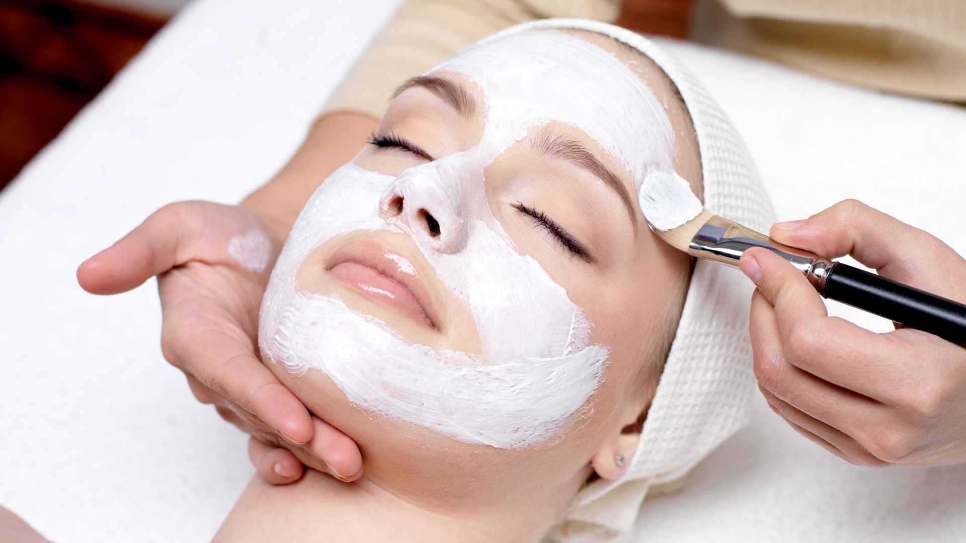 A close up of a woman 's face with her hands on it.