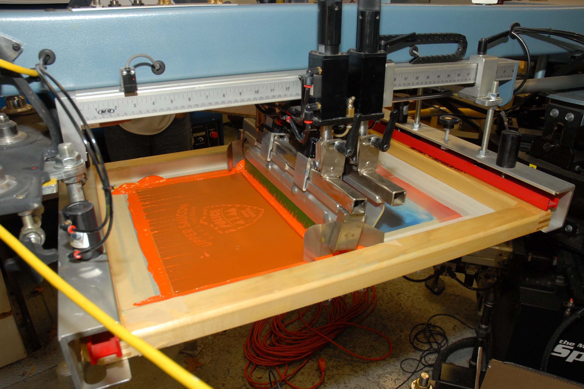 a screen printing machine is working on a piece of paper