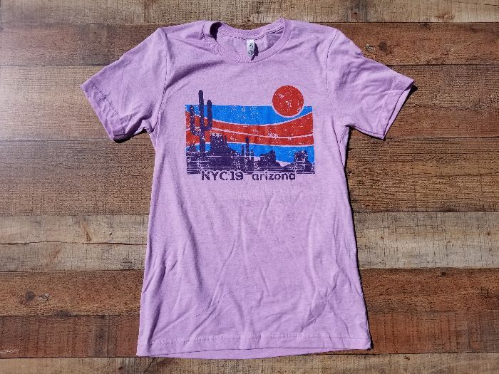 a purple t-shirt is sitting on a wooden table