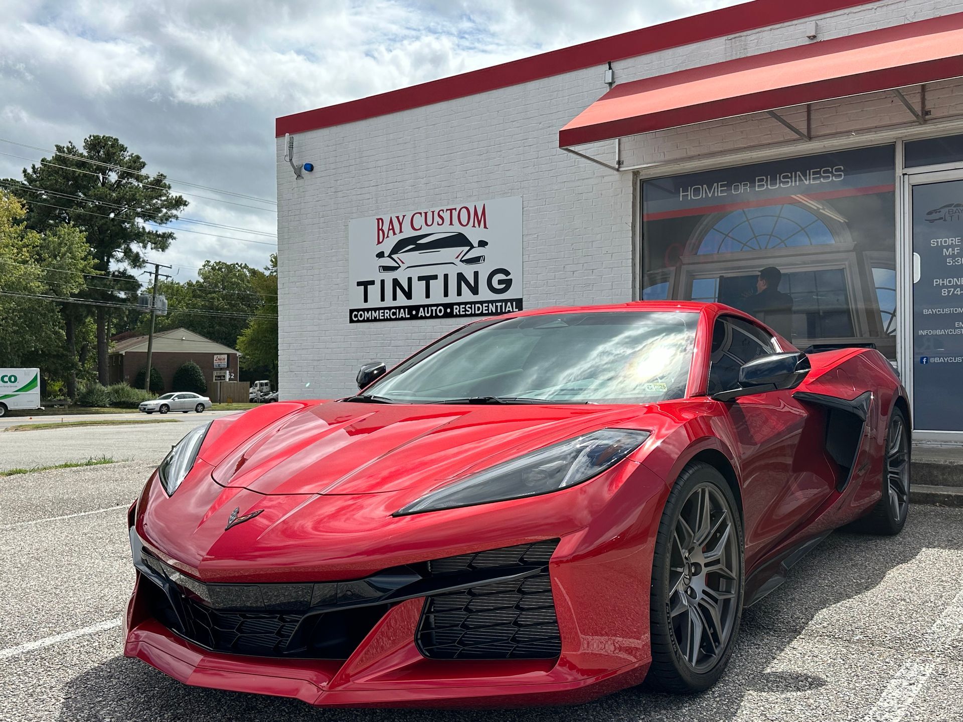A red sports car is parked in front of a building.