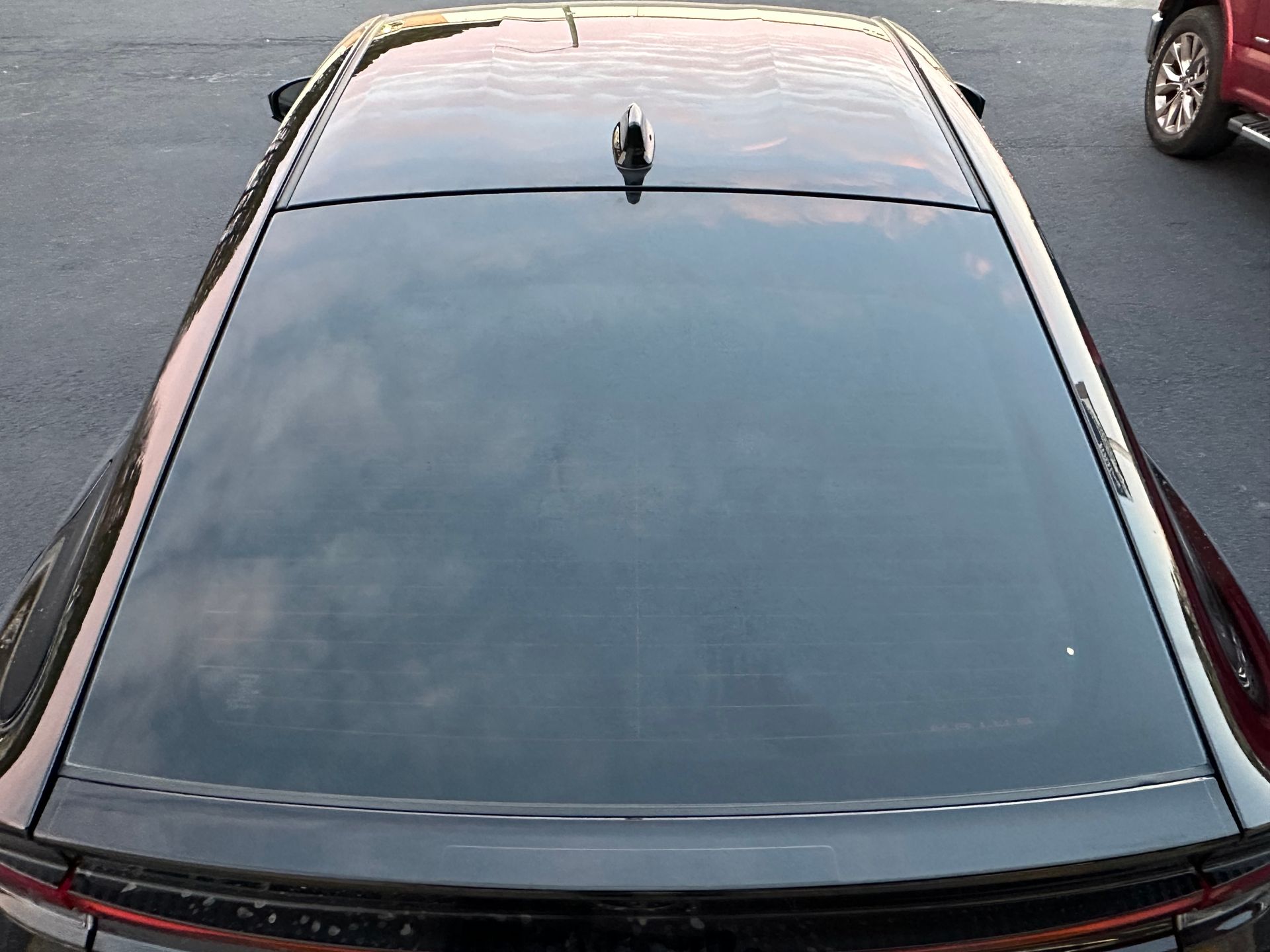A black car is parked on the side of the road.