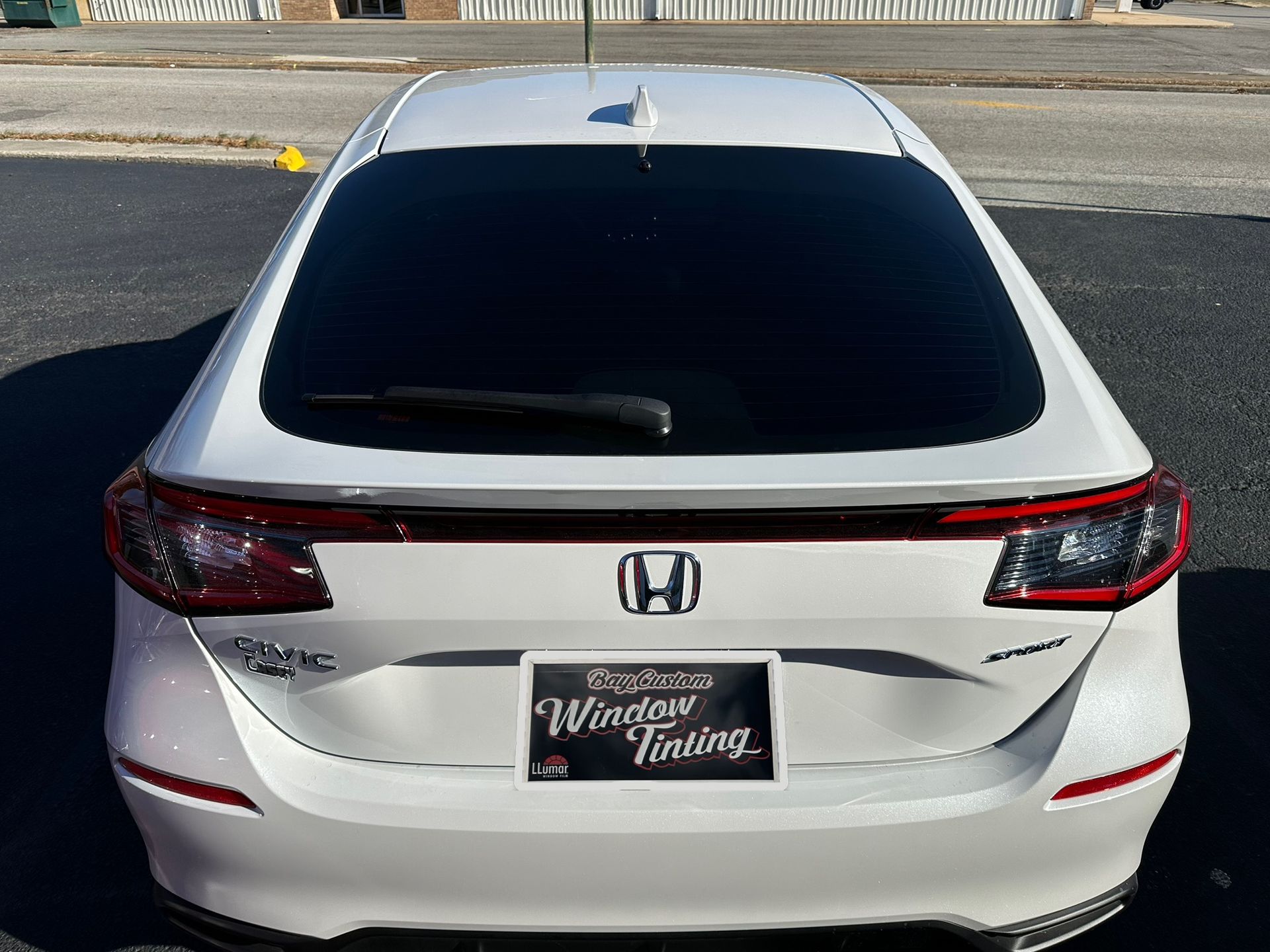 A white honda with a license plate that says window tinting