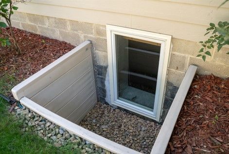 There is a window in the basement of a house.