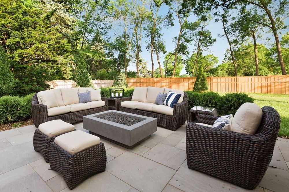 A patio with wicker furniture and a fire pit.