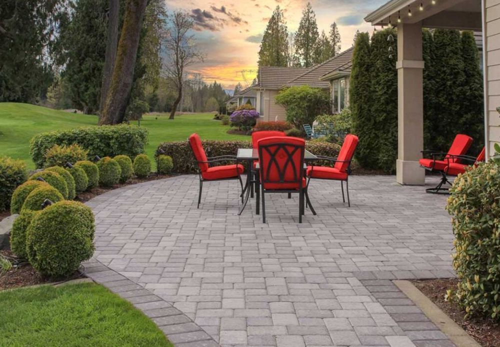 There is a patio with a table and chairs on it.