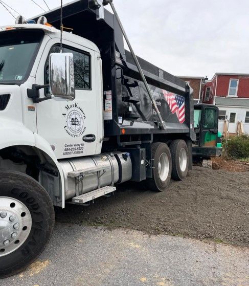 A dump truck is parked on the side of the road.