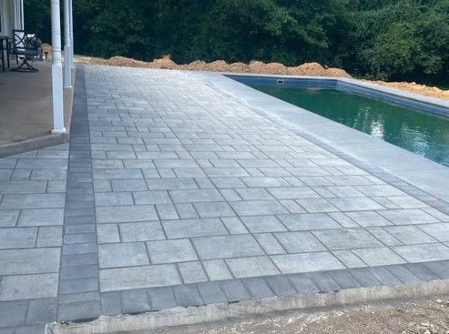 A patio with a swimming pool in the background