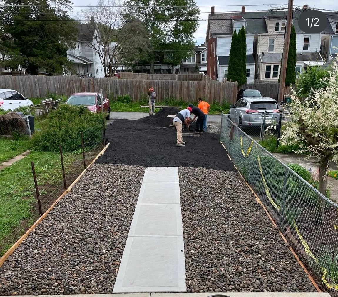 A group of people are working on a gravel driveway.