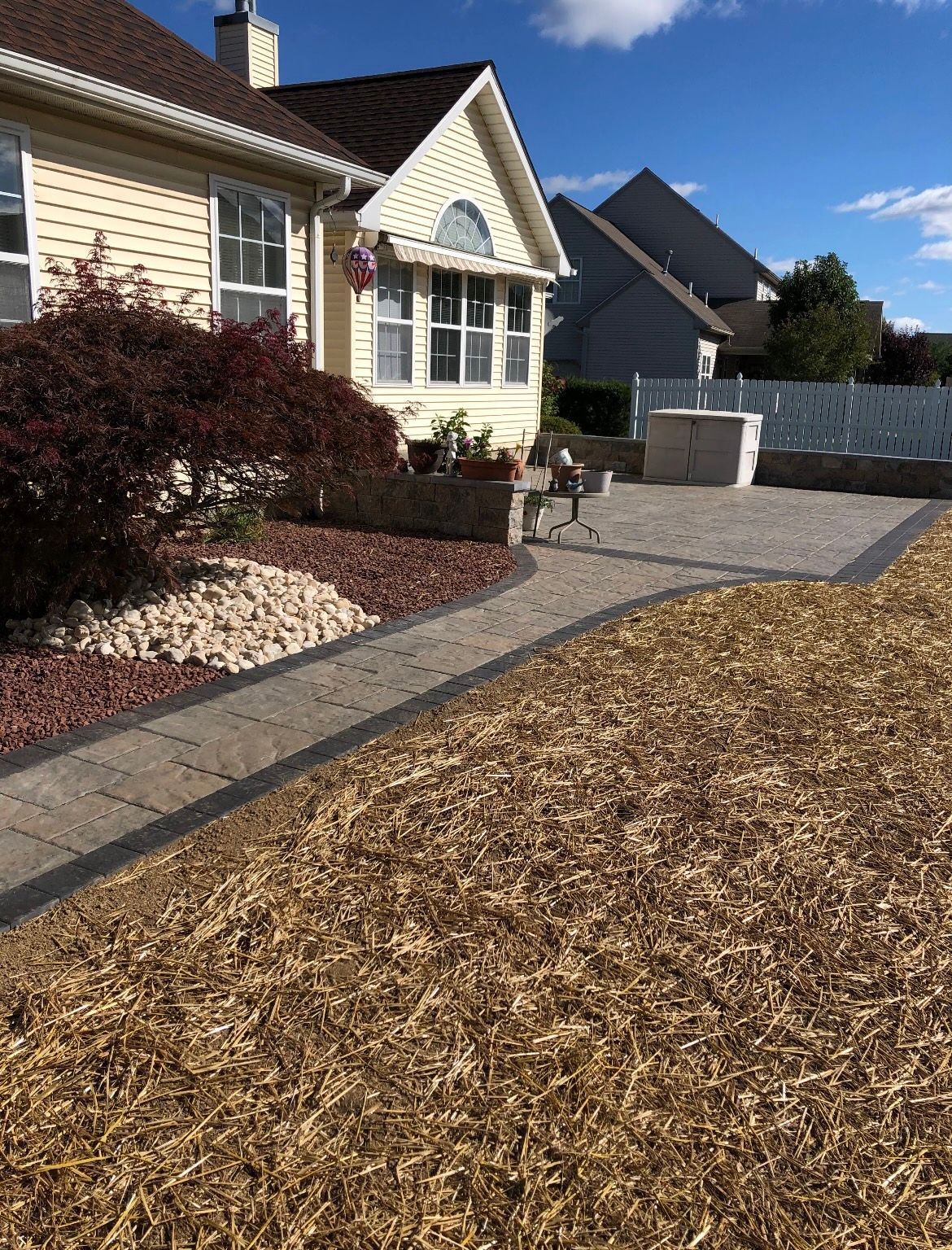 A house with a patio and a walkway in front of it.