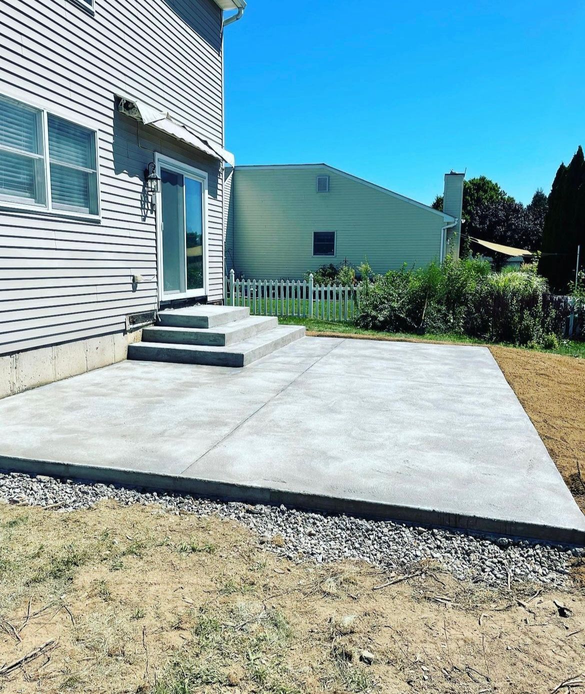 A concrete patio is being built in front of a house.