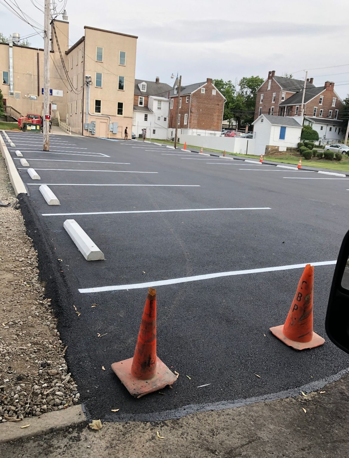 A parking lot with two orange cones on the side of it
