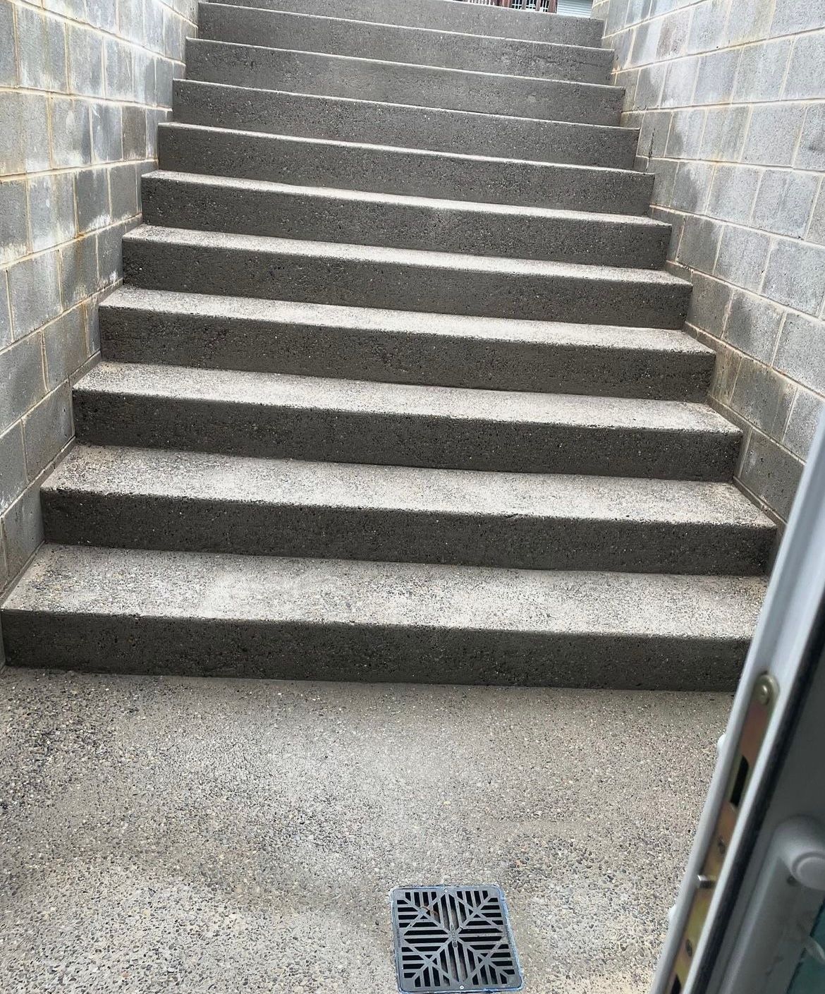 A set of stairs leading up to a brick wall.