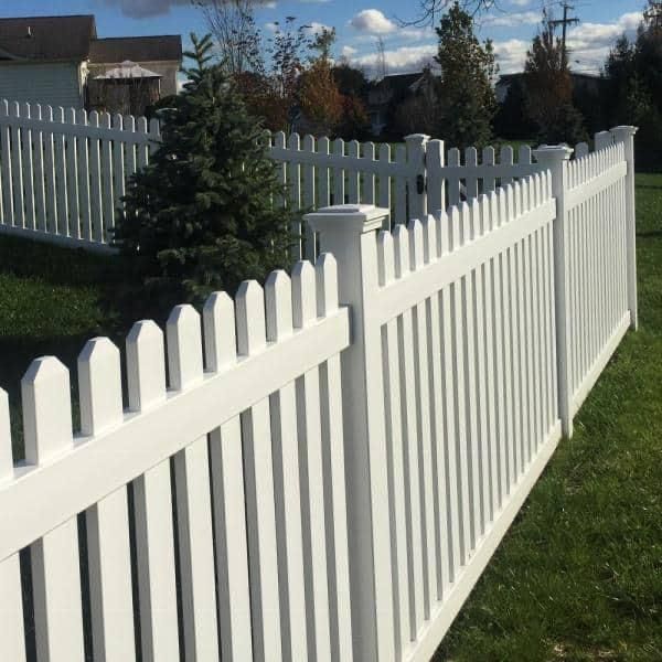 White picket fence along a grassy yard on a sunny day