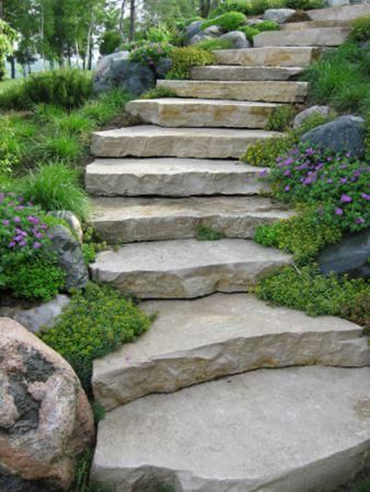 Stone garden steps winding uphill through lush greenery and purple flowers