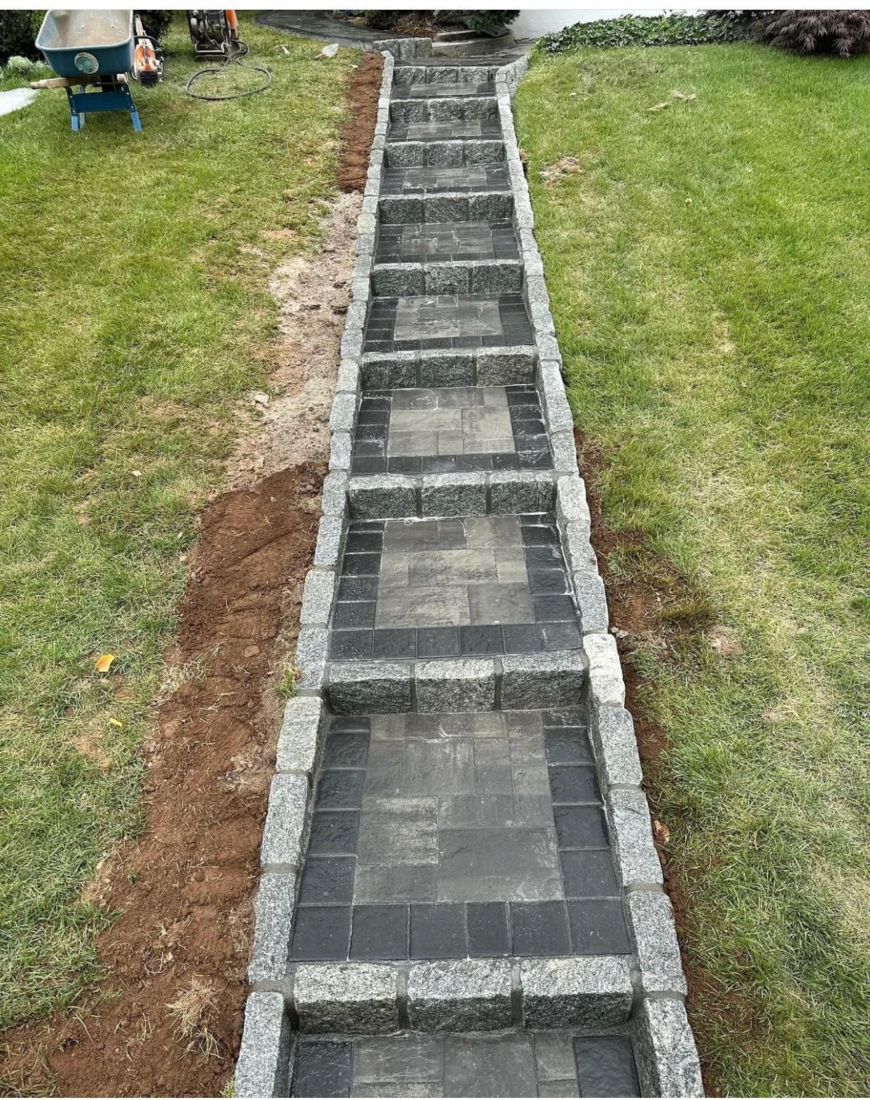 Concrete garden path under construction, bordered by grass and gravel
