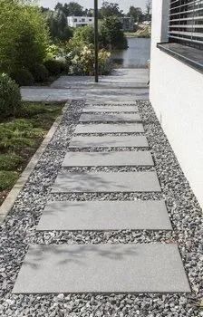 Stepping-stone walkway leading through a landscaped yard toward a water view