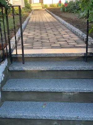 Concrete steps leading to a brick walkway in a garden path.