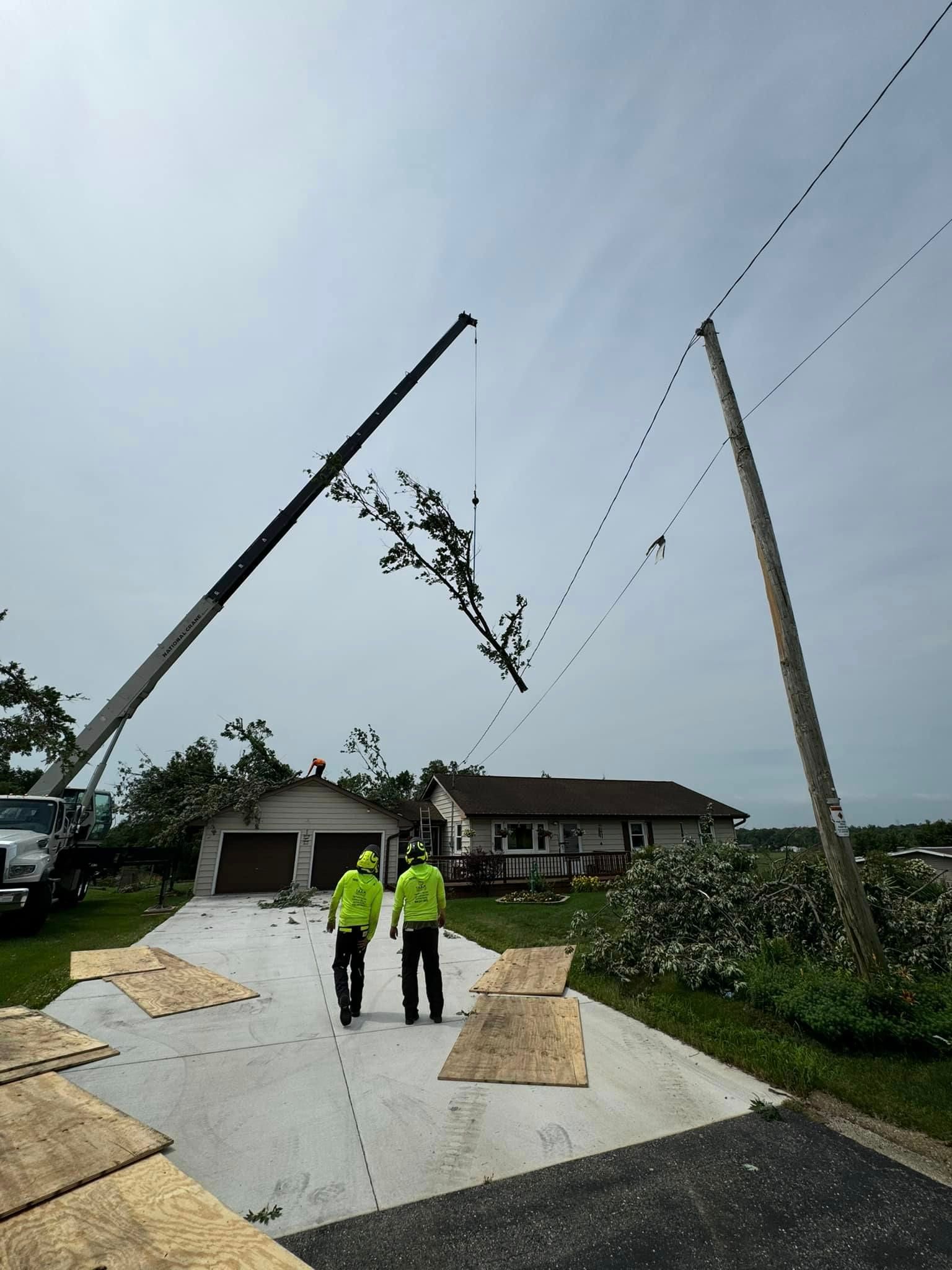 Two men are walking in front of a house with a crane in the background