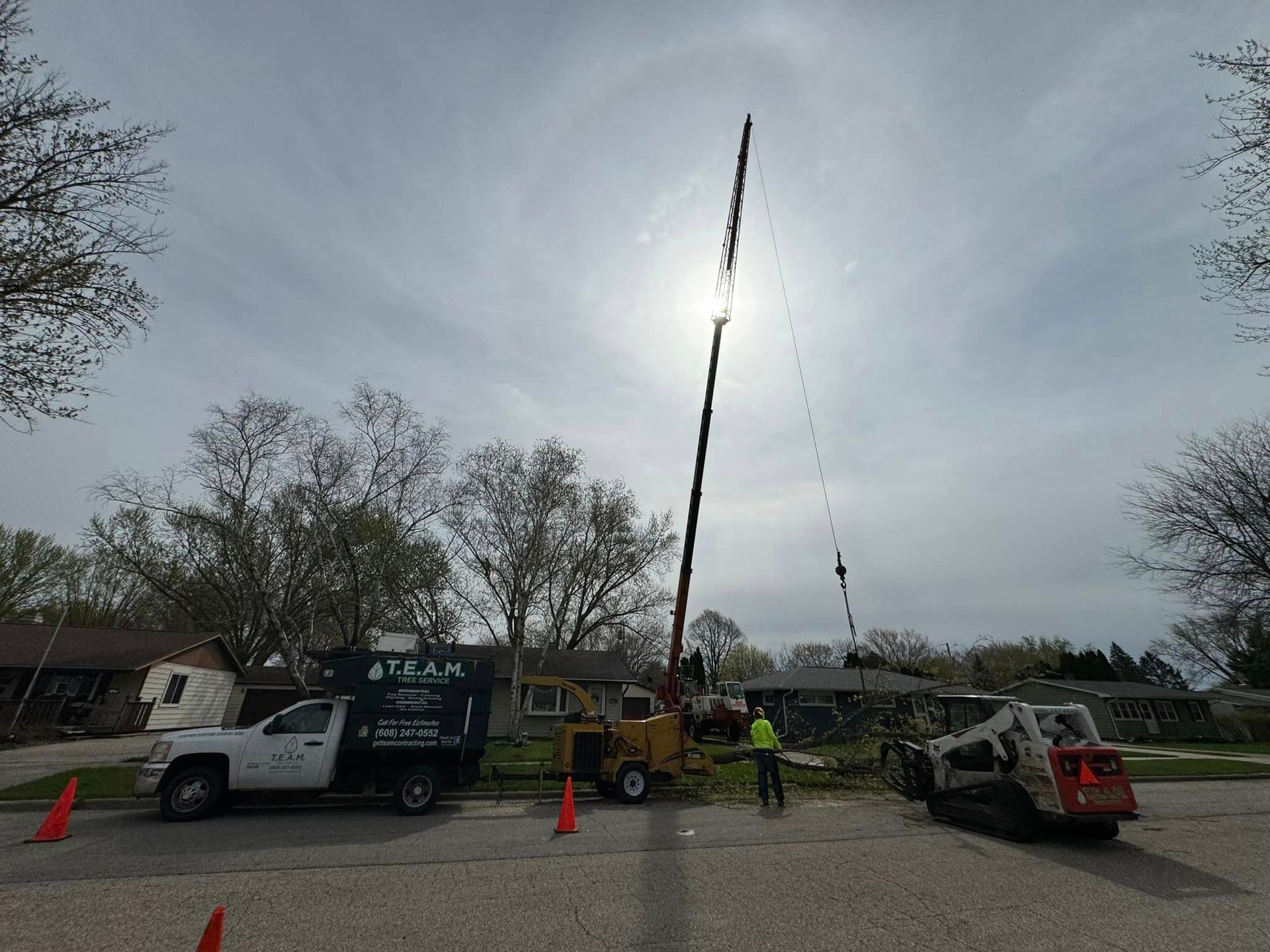 A group of trucks are parked on the side of the road in front of a house.