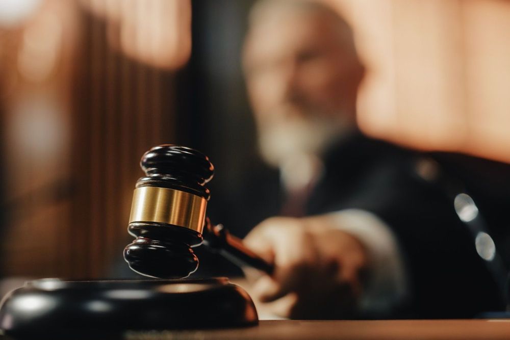 A judge is holding a gavel in a courtroom