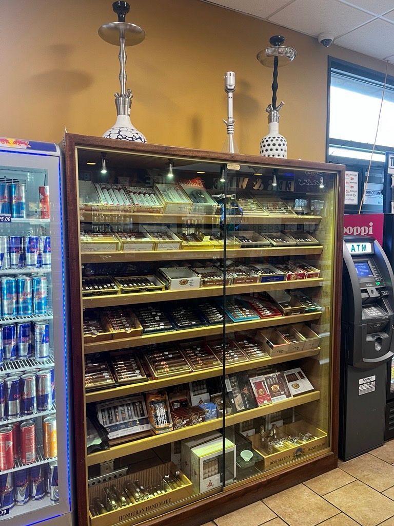 A display case filled with lots of cigars and hookahs in a store.
