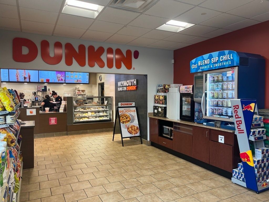 A Dunkin' Donuts store with a red bull vending machine.