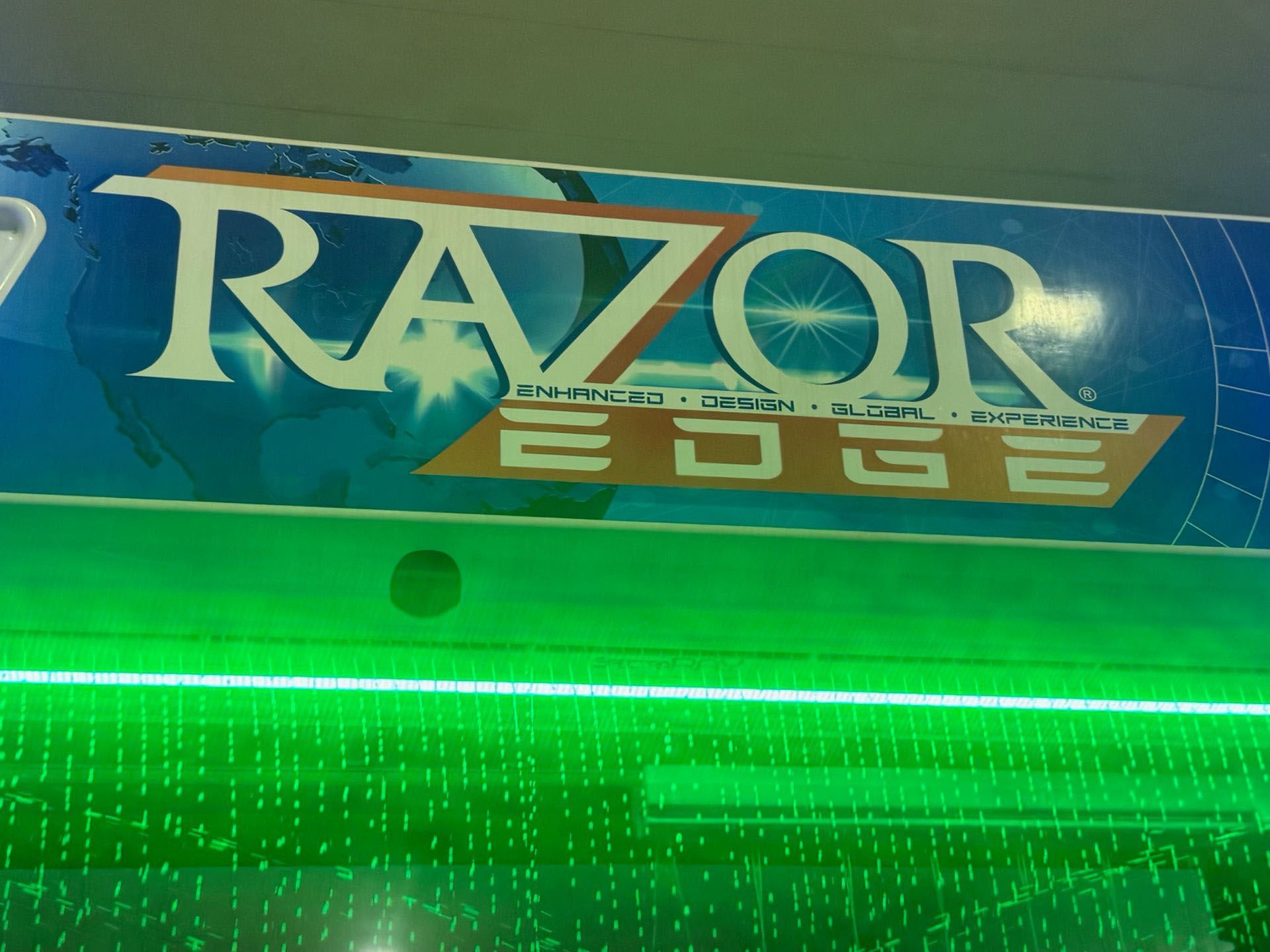 A razor edge sign with green lights behind it.