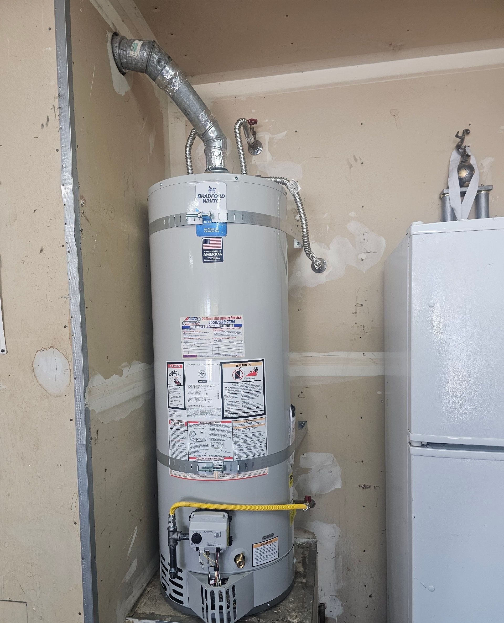 A gas water heater is installed in a wall nook. A refrigerator is visible to the right.