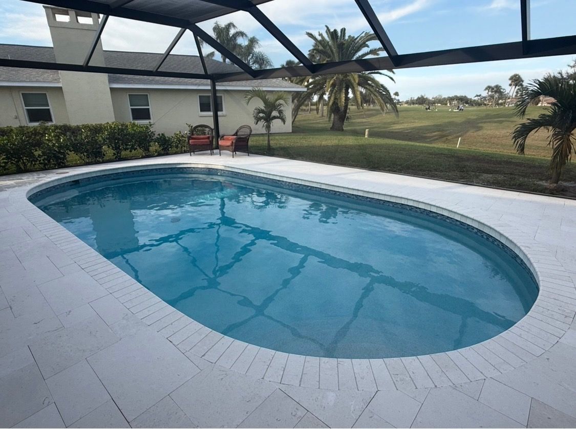 Screened-in backyard pool with blue water beside a patio and grassy yard