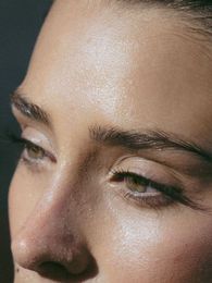 A close up of a woman 's face with a lot of sweat on it.