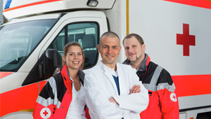 Three people in front of an ambulance