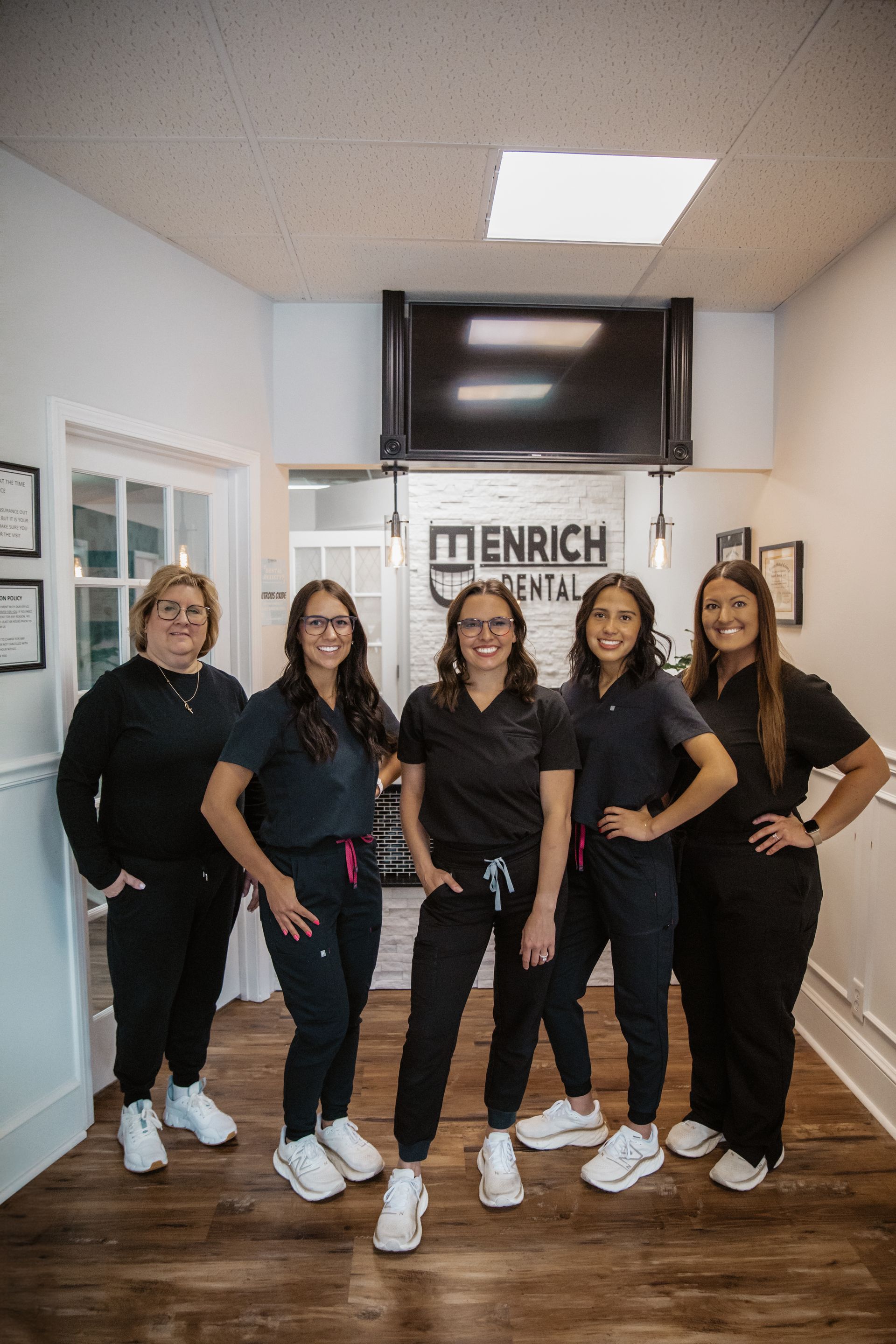A group of women are posing for a picture in a dental office.