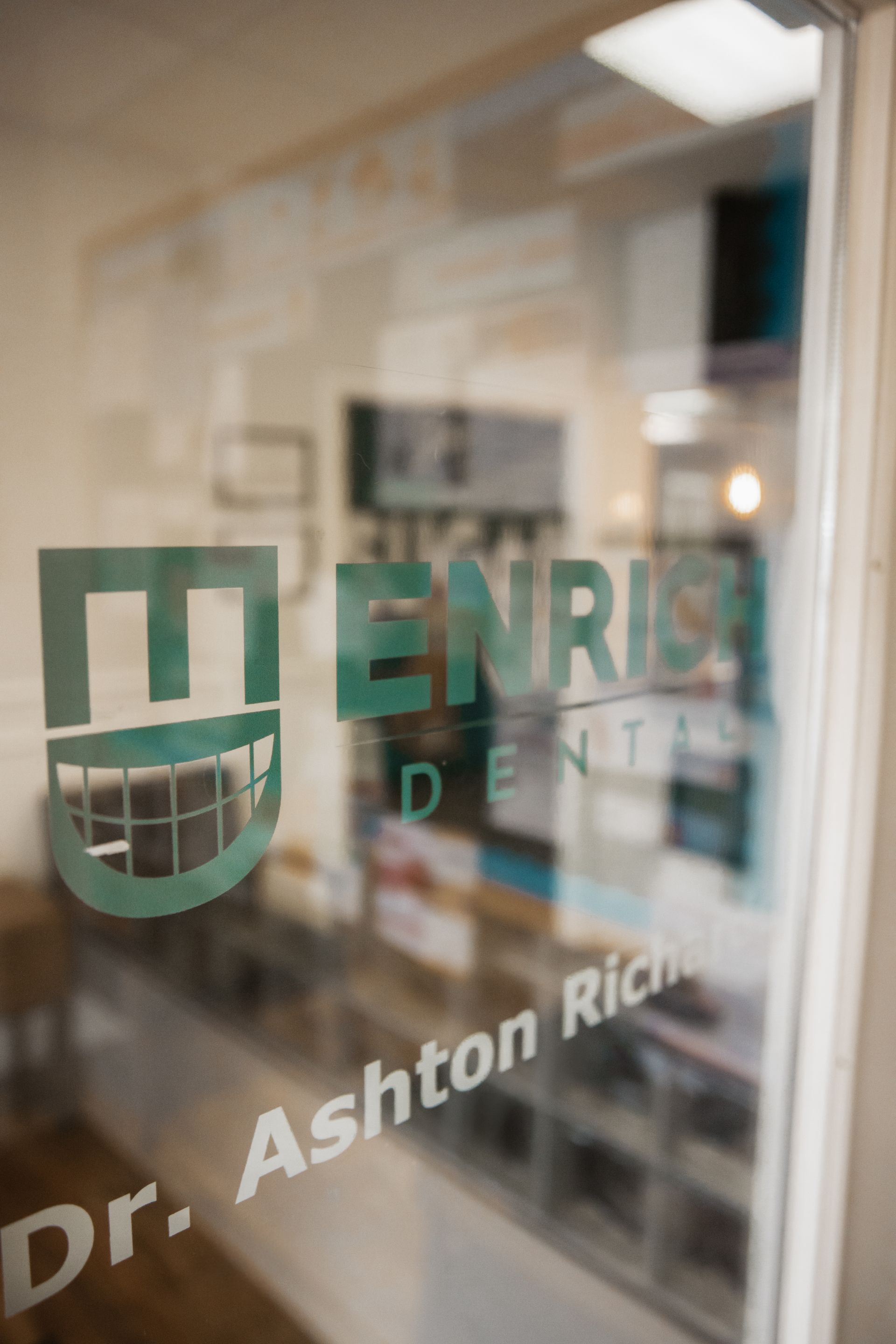 A close up of a glass door with the name dr. ashton rich on it.