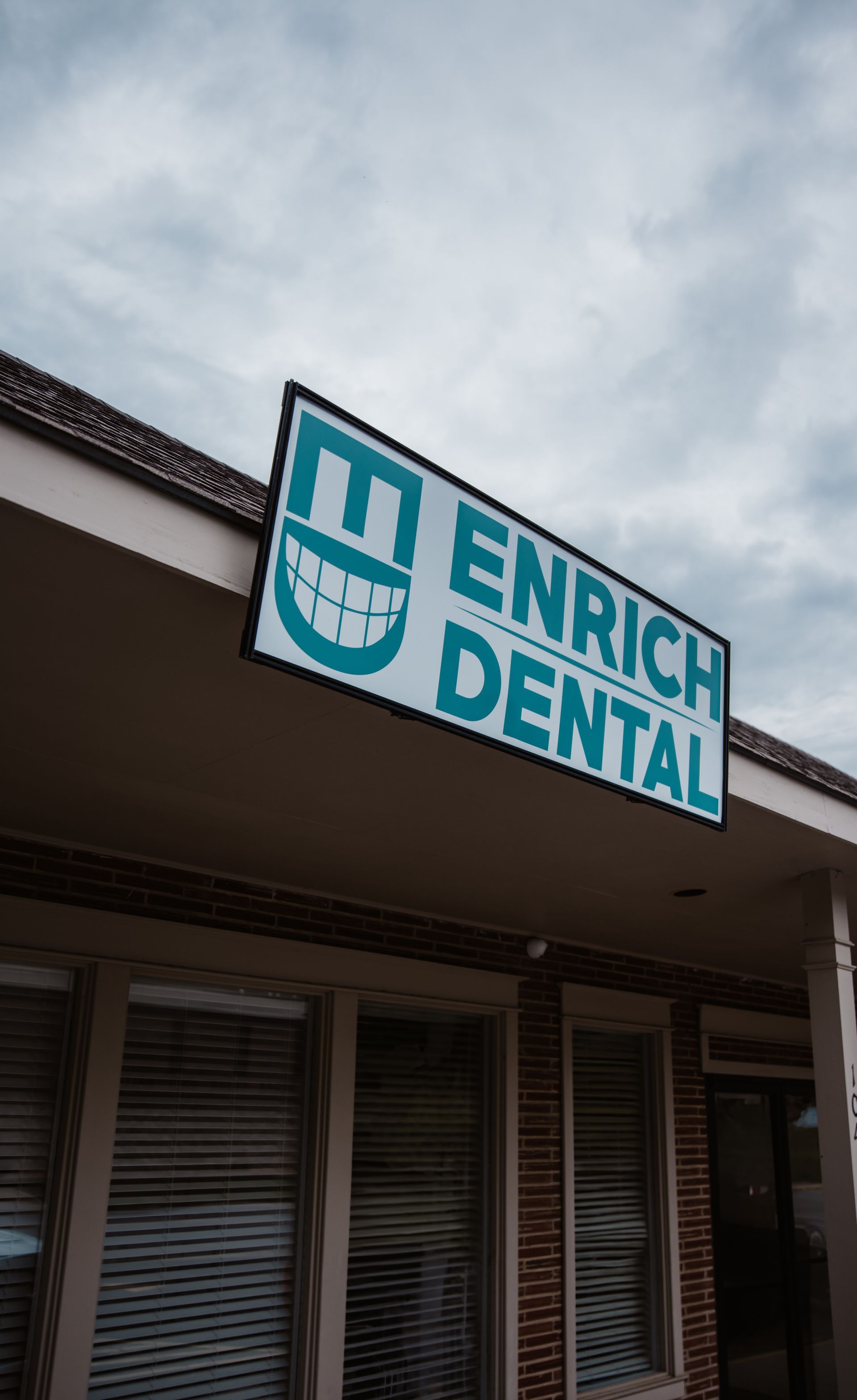 A dental office with a sign on the roof that says