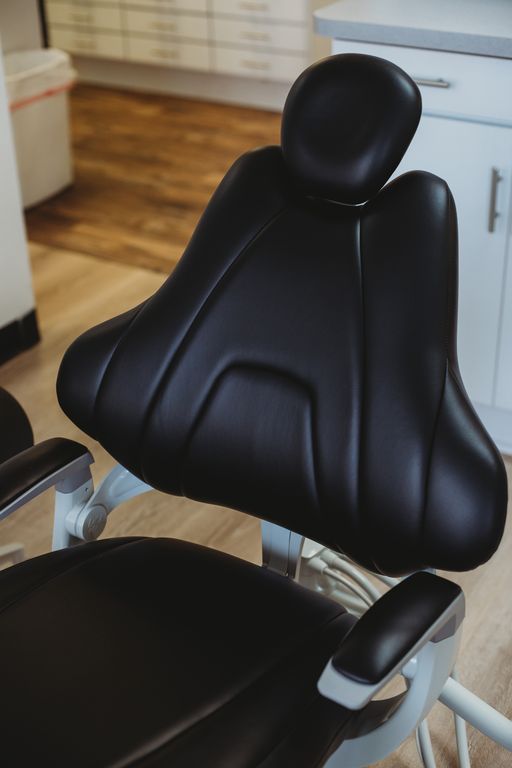 A close up of a black dental chair in a dental office